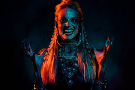 Photo for Photo of cool mad mysterious lady wear viking clothes praying demons isolated dark orange color background. - Royalty Free Image