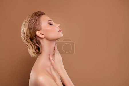 Téléchargez les photos : Photo de femme adorable brillante épaules nues profitant de douche espace vide isolé fond de couleur beige. - en image libre de droit