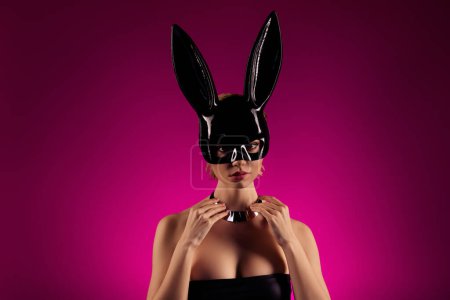 Téléchargez les photos : Photo de dame élégante célébrer halooween thème mascarade reporté costume de lapin sur fond rose. - en image libre de droit