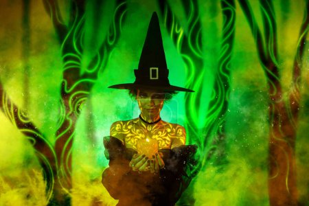 Foto de Imagen cartel collage de malvada dama hechicera celebrar vela luz fuego haciendo ritual vudú infierno hechizo en la noche verde bosque. - Imagen libre de derechos