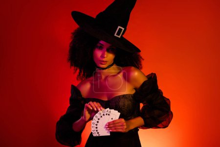 Téléchargez les photos : Photo de danger sorcière effrayante jouant au poker utiliser rituel de magie noire pour la bonne aventure dire sur la nuit d'Halloween. - en image libre de droit