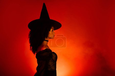 Photo for Profile soide photo of powerful lady warlock in gothic medieval village doing ritual fortune telling divination. - Royalty Free Image