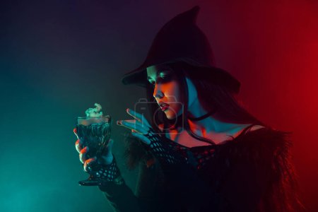Photo for Photo of devil powerful witch hold poisonous potion doing toxic mystical spell on mist neon background. - Royalty Free Image