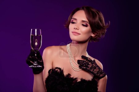 Foto de Foto de aristócrata dama rica en ocasión del evento disfrutar de celebrar el toque de champán de Navidad sobre fondo violeta. - Imagen libre de derechos