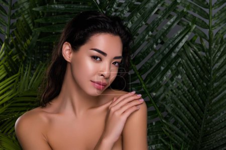 Photo for Photo of stunning asian woman charming stunning face touch shoulders off isolated tropical leaves palms background. - Royalty Free Image