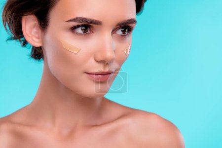 Photo for Photo of attractive lady look in cyan copyspace mirror after applying tone base foundation for glamour party. - Royalty Free Image