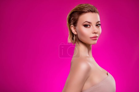 Téléchargez les photos : Photo de chic fille stand profil côté regarder miroir après l'agrandissement du sein isolé sur fond rose vif. - en image libre de droit