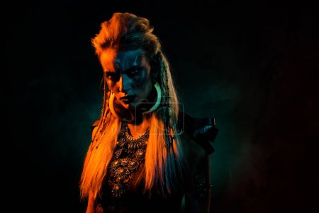 Foto de Foto de espeluznante mujer mística del norte usar traje de valquiria gótica tomando parte vikingo partido aislado color naranja fondo. - Imagen libre de derechos