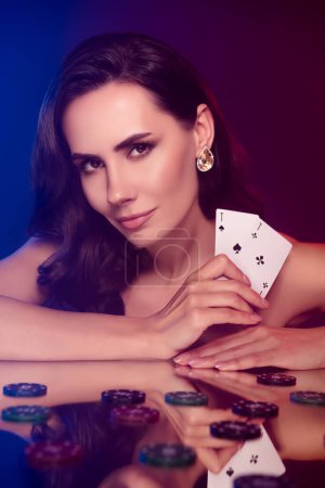 Foto de Foto de seductora dama apasionada disfrutando del juego de cartas aislado negro violeta color púrpura fondo. - Imagen libre de derechos