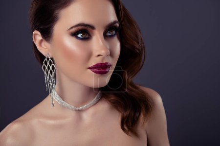 Photo for Portrait of gorgeous lady red lips combinated decorative shiny earrings and necklace isolated on gray color background. - Royalty Free Image