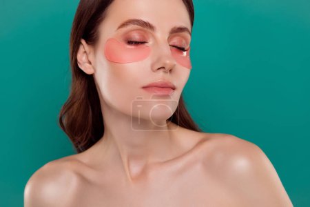 Téléchargez les photos : Photo portrait of attractive young woman eye patches self care skin spa salon isolé sur fond de couleur aigue-marine. - en image libre de droit