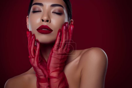 Photo for Photo of asian young girl femme fatale touch cheeks closed eyes tease shoulders off isolated dark red color background. - Royalty Free Image