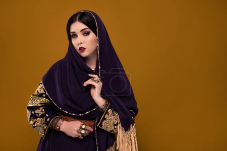 Foto de Foto de la bella dama princesa árabe usar hijab para viajar desierto largo para sultán rico sobre fondo pastel. - Imagen libre de derechos