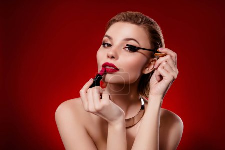 Téléchargez les photos : Photo de chic fantaisie femme épaules nues application maquillage vide espace isolé rouge fond de couleur marron. - en image libre de droit