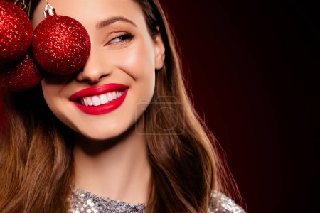 Téléchargez les photos : Gros plan photo de joyeux jolie fille tenir près du visage avec boules sapin de Noël préparer événement occasion. - en image libre de droit