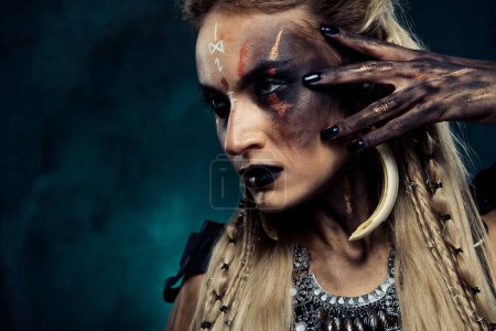 Téléchargez les photos : Gros plan photo de dame préparer thème cosplay Halloween festival touche maquillage habillé en personnage viking. - en image libre de droit