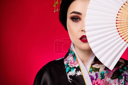 Photo for Photo of gorgeous lady dressed kimono hand hold traditional japanese fan empty space isolated on red color background. - Royalty Free Image