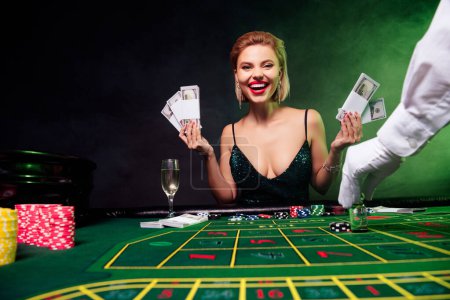 Foto de Foto de chica atractiva feliz disfrute de la apuesta de bluff en vip casino club hold dollars black jack jackpot winning. - Imagen libre de derechos