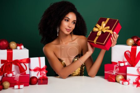 Photo for Photo of attractive gorgeous stunning lad promoting gift box special offer ob christmas over green background. - Royalty Free Image