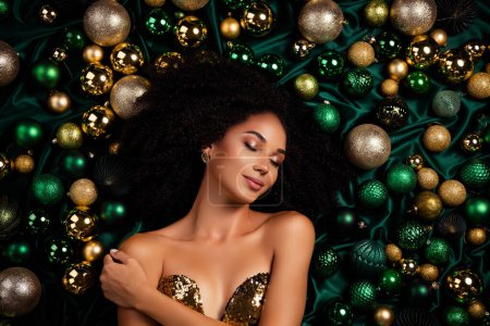 Foto de Vista superior estudio retrato de la hermosa dama que pone entre el árbol de Navidad de oro de lujo adornos brillantes ojos cerrados tocar la piel. - Imagen libre de derechos