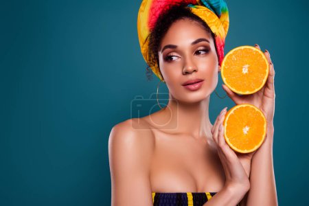 Foto de Foto de elegante chica safari sabana vivienda mercado de comercio con frutas naranjas frescas sobre fondo de color azul. - Imagen libre de derechos