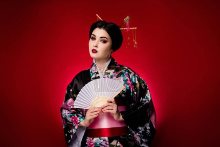 Téléchargez les photos : Photo de belle dame élégante portant la robe japonaise traditionnelle bénéficiant de la paix isolé sur fond de couleur dégradé rouge. - en image libre de droit