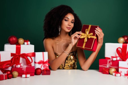 Téléchargez les photos : Photo de chic dame promoteur cadeau boîte cadeau offre spéciale seulement pour Noël sur fond de couleur verte. - en image libre de droit