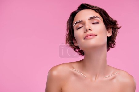 Photo for Portrait of elegant woman enjoying expensive 8 march present pearls decor on eye brows breast over pink background. - Royalty Free Image