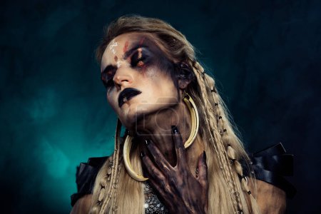Téléchargez les photos : Photo de dame viking occulte toucher chaman en transe magique parler avec diable démon sur fond sombre. - en image libre de droit