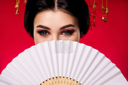 Photo for Photo of sophisticated elegant lady hiding face japanese fan traditional isolated on red gradient color background. - Royalty Free Image