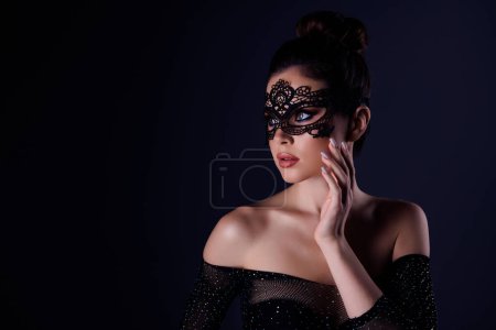 Téléchargez les photos : Photo de charmante dame croupier marchand de casino porter masque de couture au club de poker isolé sur fond de couleur sombre. - en image libre de droit