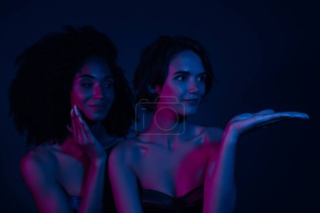 Photo for Photo of stunning chic lady promoter touch demonstrate beauty product for perfect smooth skin on neon background. - Royalty Free Image