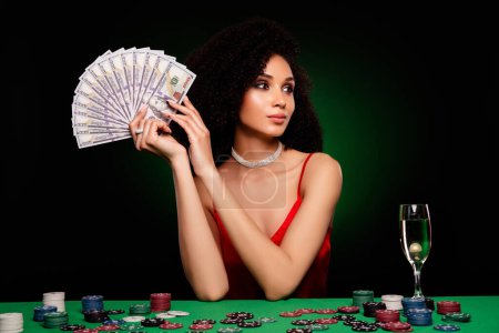 Foto de Foto de elegante dama encantadora caliente con millones de dólares anuncian arriesgado juego de póquer aislado sobre fondo verde oscuro. - Imagen libre de derechos