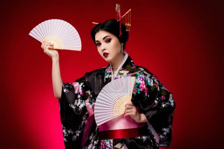 Téléchargez les photos : Photo de dame asiatique adorable habillé robe symbolique kimono danse traditionnelle isolé sur fond de couleur dégradé rouge. - en image libre de droit
