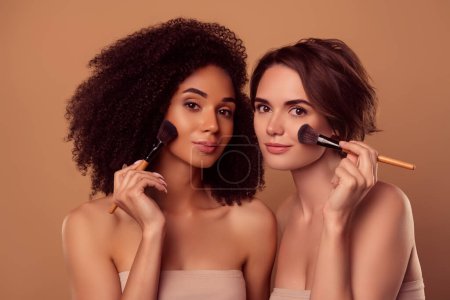 Photo for Photo of two tender gentle applying rouge powder on cheeks prepare for party over pastel background. - Royalty Free Image