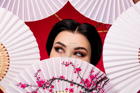 Photo for Photo of graceful elegant asian lady close face japanese folding fan looking up empty space on red color background. - Royalty Free Image