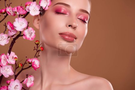 Téléchargez les photos : Photo de magnifique dame magnifique avec fleur de cerisier rose profiter de lotion asiatique phytothérapie procédure. - en image libre de droit