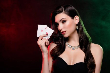 Foto de Foto de la rica dama elegante en el club de póquer jugando muestran dos cartas ganando sobre fondo oscuro. - Imagen libre de derechos