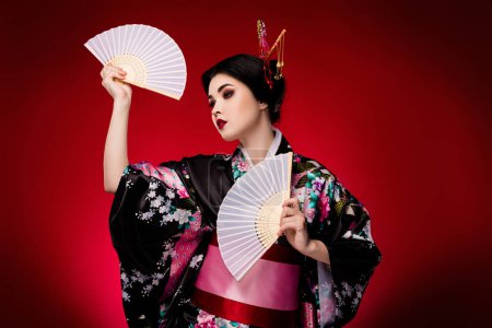Foto de Foto de señora coreana negro elegante vestido kimono danza teatro rendimiento aislado en rojo degradado color fondo. - Imagen libre de derechos