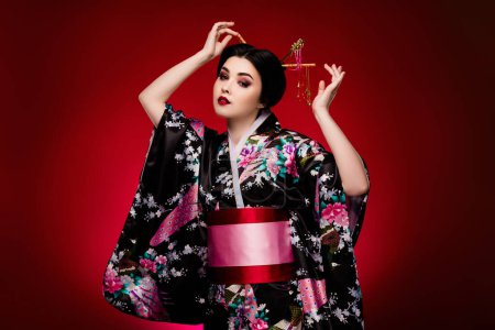 Foto de Foto de hermosa hermosa señora asiática geisha vestida con kimono vestido tradicional aislado sobre fondo de color rojo degradado. - Imagen libre de derechos