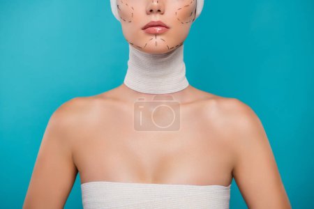 Téléchargez les photos : Photo recadrée d'une patiente préparant une chirurgie plastique Augmentation mammaire sur fond de cyan. - en image libre de droit