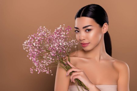 Photo for Portrait of lady pefect silky pure skin hand hold nice flowers herbal gel serum isolated on beige color background. - Royalty Free Image