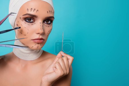 Photo for Photo of lady patient having plastic surgery with medical tools isolated over cyan color background. - Royalty Free Image