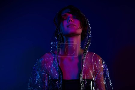 Foto de Foto de atractiva chica cool disfrutar de desgaste waterpoof traje capucha aislado vibrante fondo. - Imagen libre de derechos
