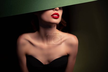 Téléchargez les photos : Portrait de séduisante dame séduisante chic posant visage fermé avec plaque verte espace vide isolé sur fond sombre. - en image libre de droit