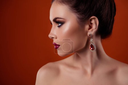 Foto de Foto de perfil de señora rica romántica con costosos pendientes de gemas mirar espacio de copia aislado en el fondo de color rojo. - Imagen libre de derechos