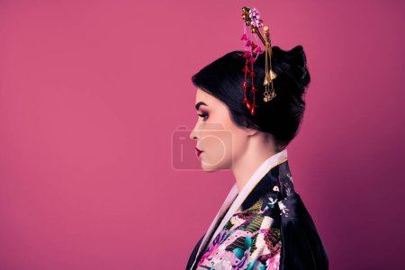 Téléchargez les photos : Profil côté photo de magnifique fille porter costume traditionnel et regarder l'espace vide sur fond dégradé de couleur rose. - en image libre de droit