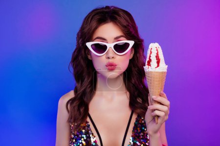 Foto de Foto retrato de encantadora joven regordeta labios beso celebrar helado verano aislado en retro neón luz fondo. - Imagen libre de derechos