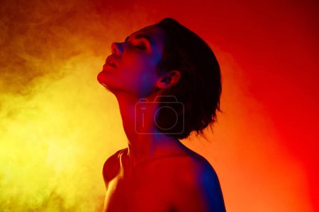 Téléchargez les photos : Photo de jolie femme séduisante épaules nues profitant sauna à vapeur isolé rouge fond de couleur néon. - en image libre de droit