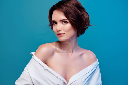 Photo for Photo of dreamy bob brown hair model with bare shoulders wearing white shirt isolated on blue color background. - Royalty Free Image